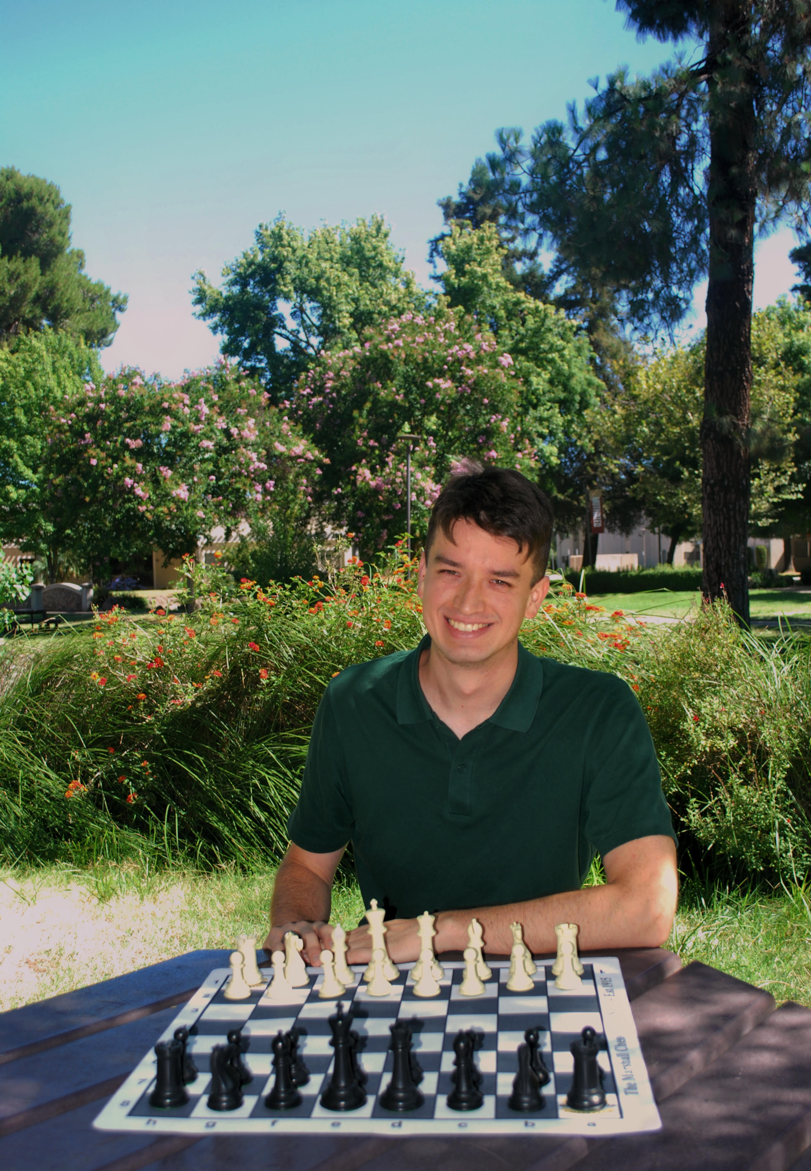 Aaron Thompson seated at a chessboard outdoors